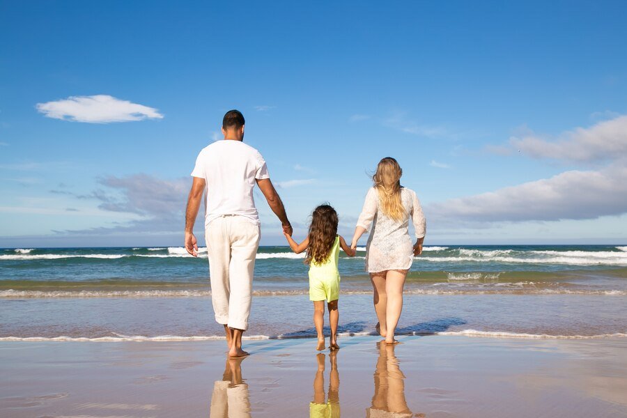 Familia andando na praia com criancas