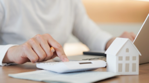 Pessoa calculando imposto ITBI em Calculadora e computador